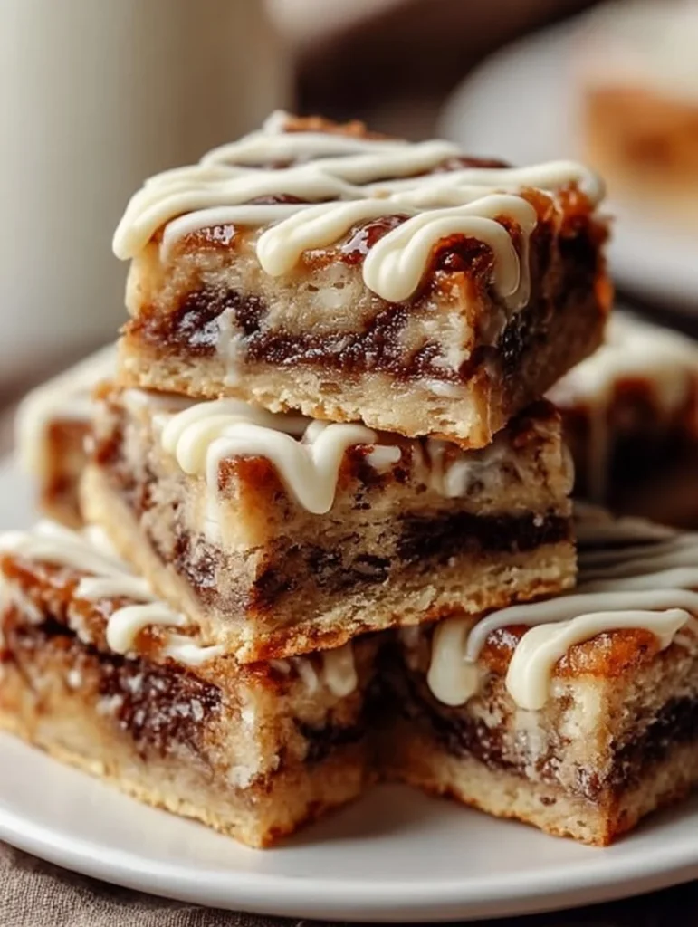 Deliciously moist Cinnamon Roll Bliss Bars drizzled with icing on a plate