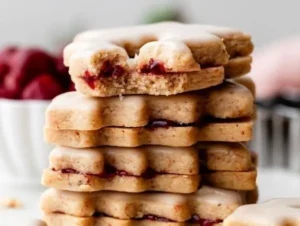 Iced Cherry Almond Linzer Cookies garnished with cherry and almond flavors